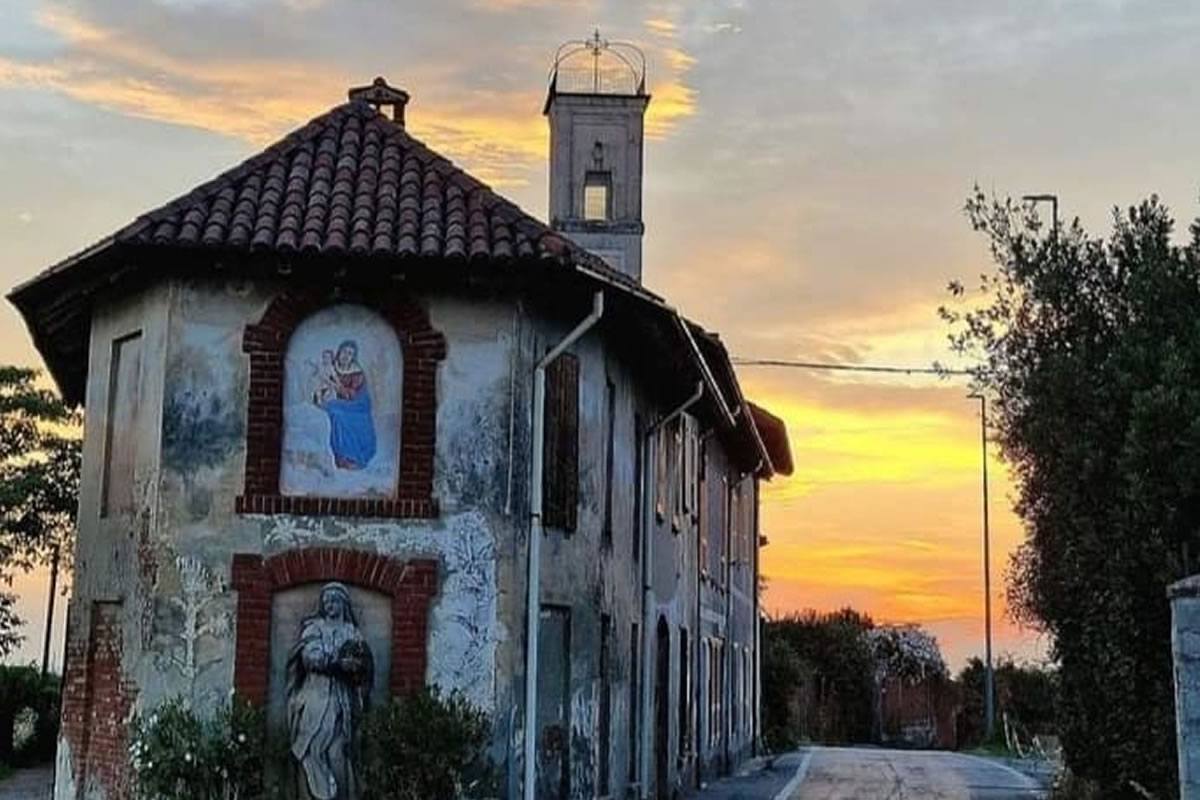 Chiesa di campagna con affreschi religiosi, cielo al tramonto. Architettura storica, arte sacra, azienda agricola I Germogli.
