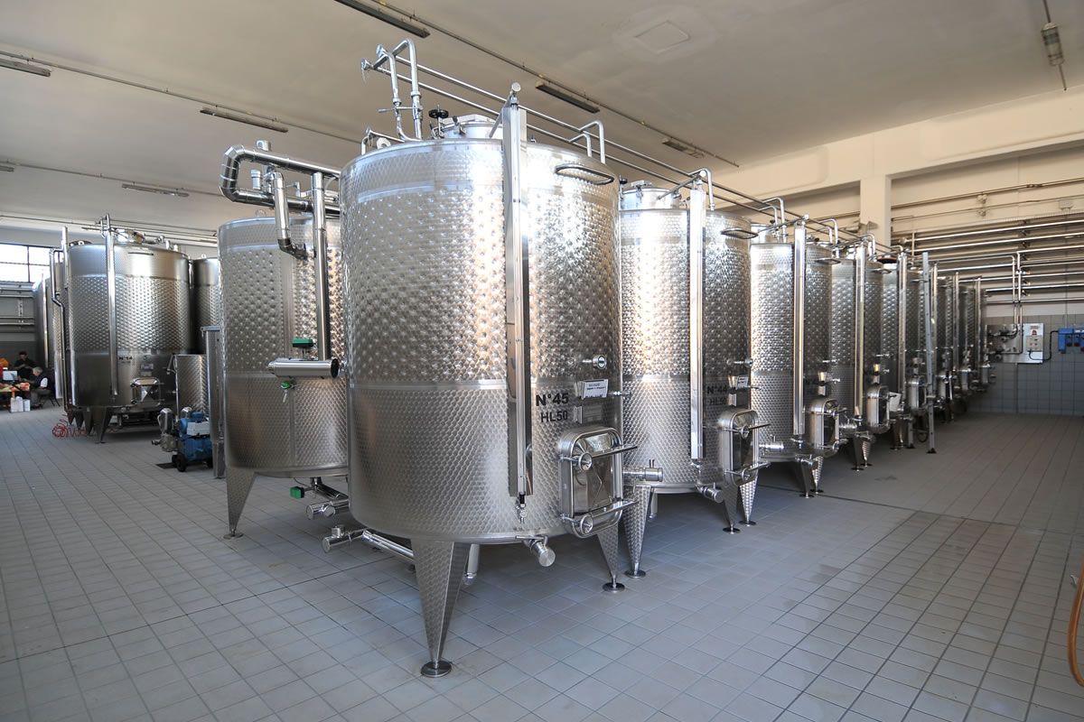Serbatoi in acciaio inox in una cantina vinicola. Produzione vino, fermentazione, stoccaggio. Poderi San Pietro.